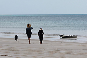 Image of a person taking their dog onto the beach at K'gari (Fraser Island).