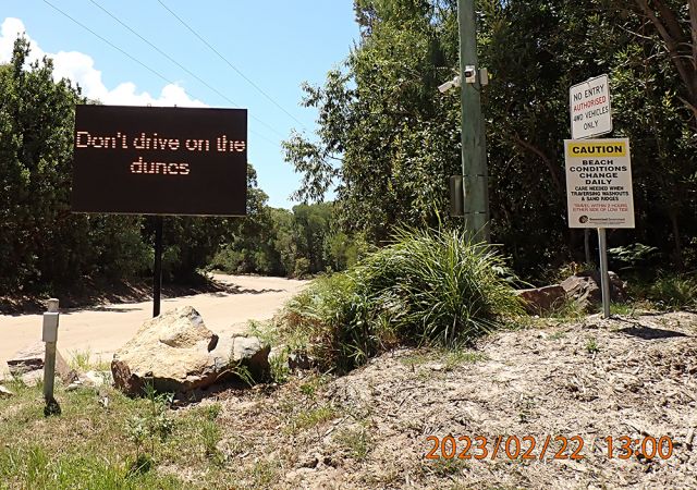 Photo of signage advising drivers that vehicles are prohibited from driving on Bribie Island Dunes.